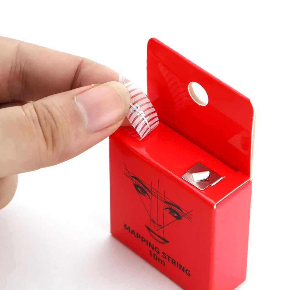 A hand holds a red box containing a mapping string for microblading