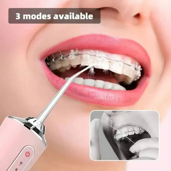 A pink electric water flosser is shown being used on a person's mouth to clean teeth.