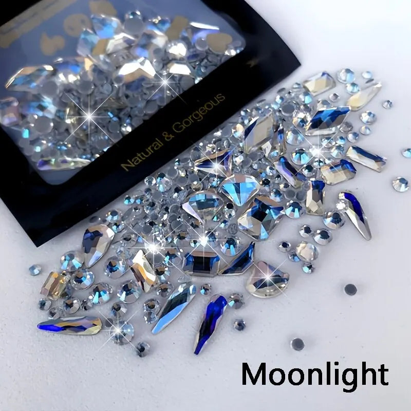 A pile of iridescent and blue glass rhinestones for nail art and DIY crafts under moonlight lighting.