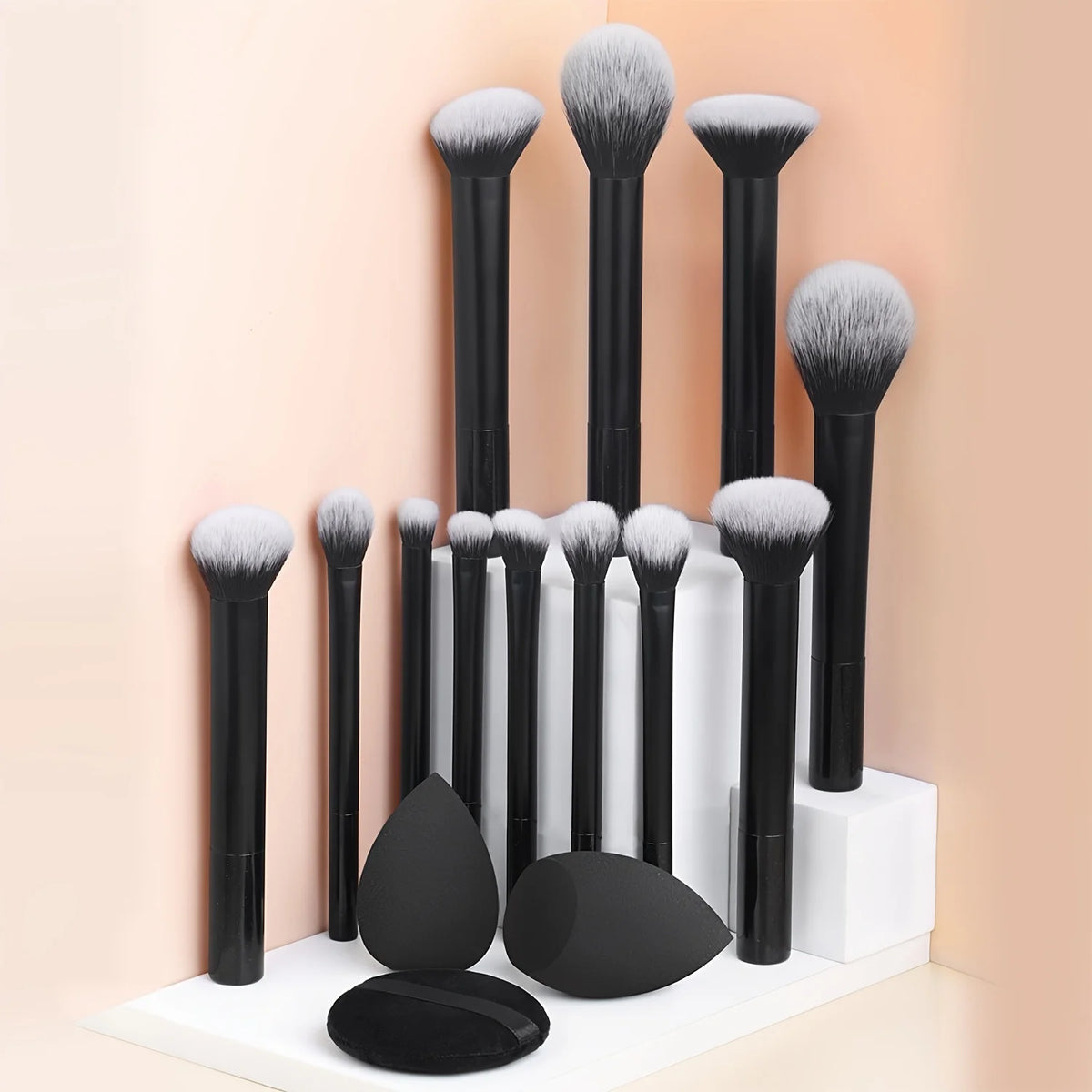Una colección de doce brochas de maquillaje profesionales en varios tamaños y tonos, mostradas contra un fondo claro.