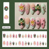 Colección de uñas postizas rosas y verdes con diseños de mariquitas y acentos florales.