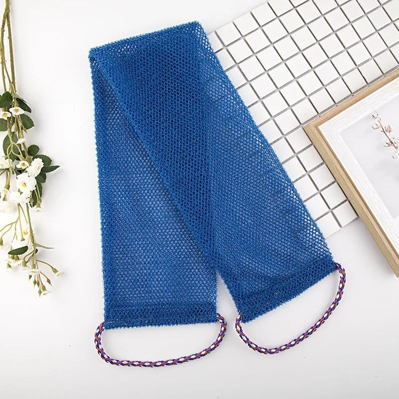 A royal blue exfoliating net body scrub sponge lying next to a spiral notebook and a framed picture.
