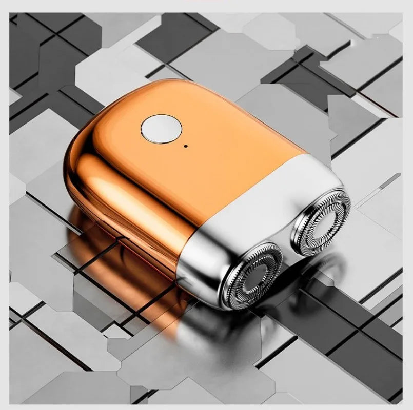A small, orange and silver electric beard trimmer shaver resting on a geometric gray surface.
