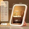A modern LED vanity makeup mirror with a light frame and adjustable lighting is shown in a bedroom setting.