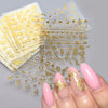 Gold star nail art stickers and decals for acrylic nails displayed on a hand.
