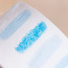 A white hair dressing collar with blue stripes is shown in a close-up view.