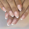 A close-up of hands displaying a set of white French style coffin shaped press-on nails
