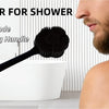 A man is using a black long-handle back scrubber for shower on his shoulder.