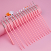 A collection of pink professional nail art brushes and tools arranged diagonally on a pink background.