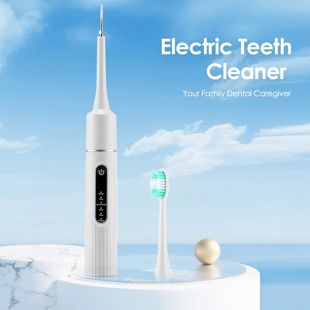 A white electric teeth cleaner toothbrush standing upright on a marble surface with a green toothbrush next to it.