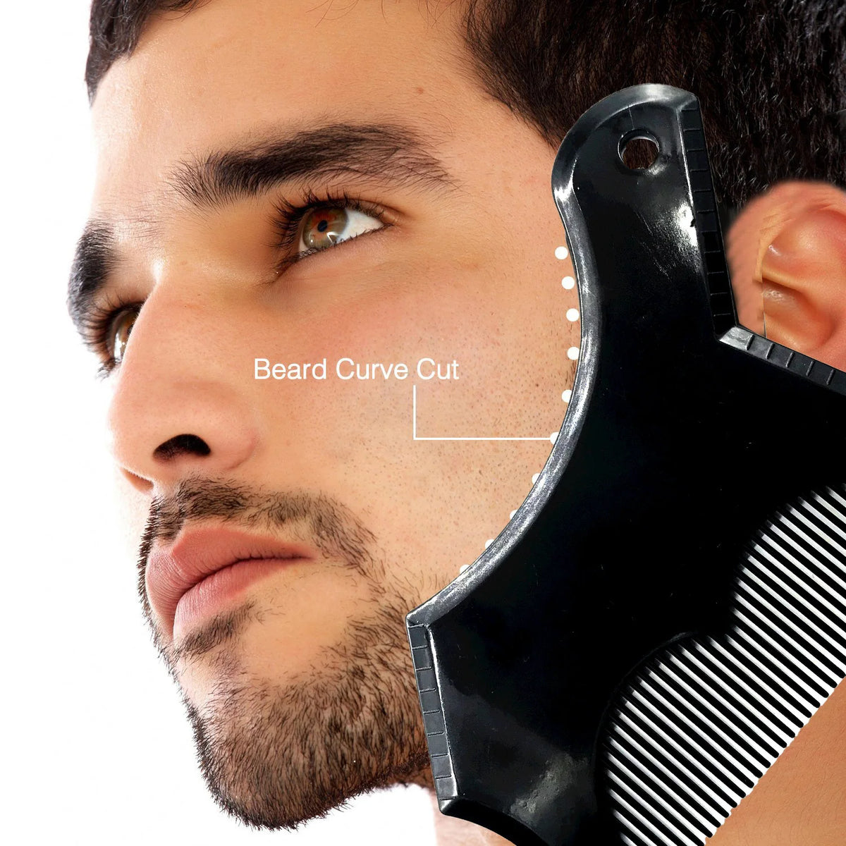 A close-up of a man's face showing the application of a black beard curve cut tool on his cheek.