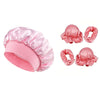 A set of pink satin sleep caps, hair curlers, and claw clips for styling hair.