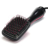 A black professional hot air hair dryer brush with numerous fine bristles and a handle is shown against a white background.