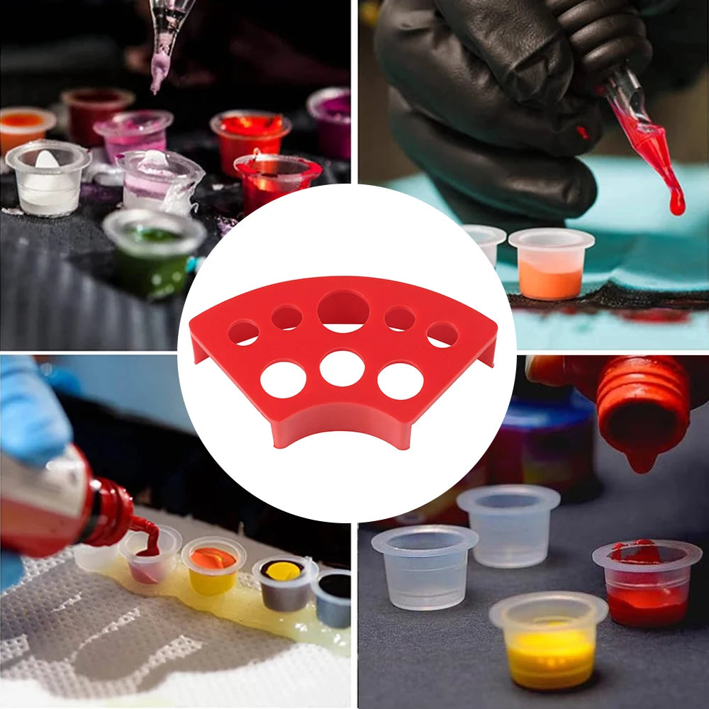 A set of red tattoo ink cups with a holder, showing various colors and sizes for disposable use.