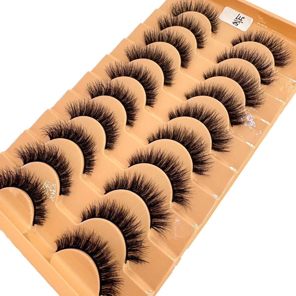 Un plateau de faux cils de renard faits à la main, arrangés en rangées pour usage cosmétique.