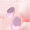 A pink silicone sonic facial cleansing brush is shown against a light pink background.
