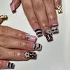 Press-on nails featuring a blue and brown French wave design with star accents on a natural nail bed.