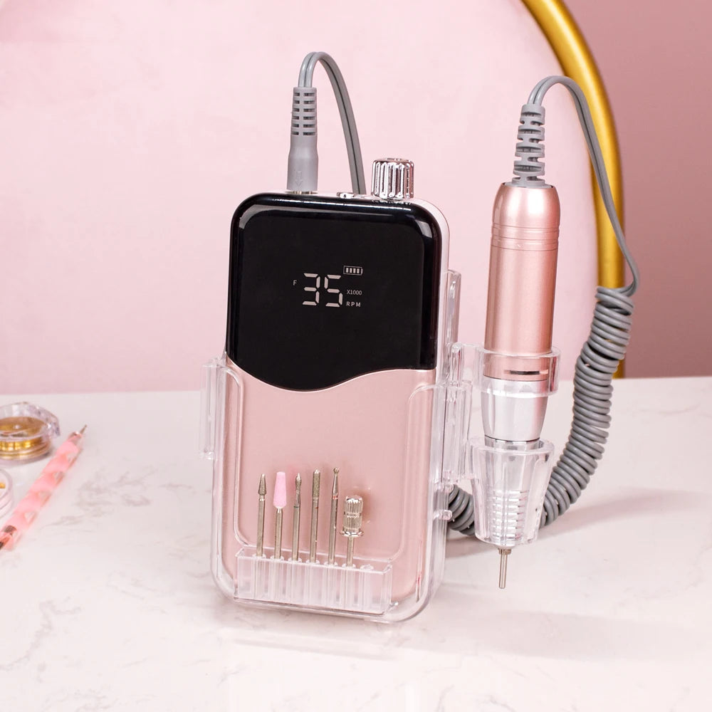 A pink cordless rechargeable nail drill with a clear housing and a metallic drill bit is shown on a white surface.