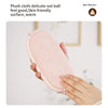 Eine Hand hält einen rosa Plüsch-Gürtelwärmer für Bauchmassage.