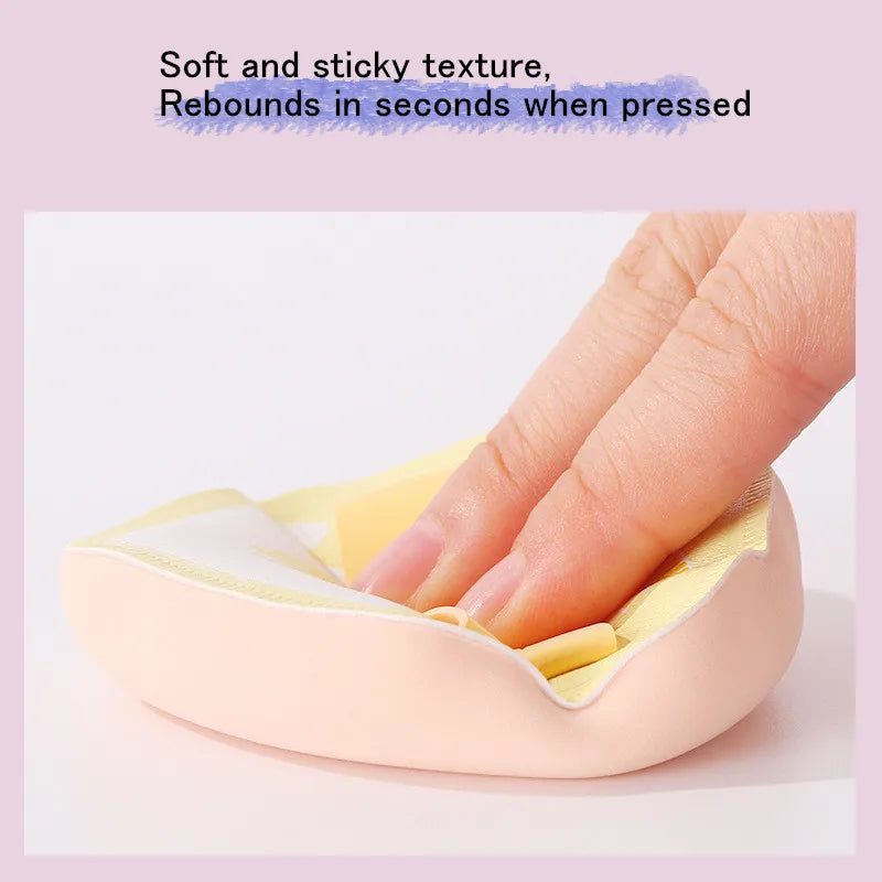 Une main presse un tampon de maquillage rose et doux dans une éponge jaune pour l'application.