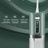 A close-up of a portable electric oral irrigator in a mint green color with a clear water reservoir.