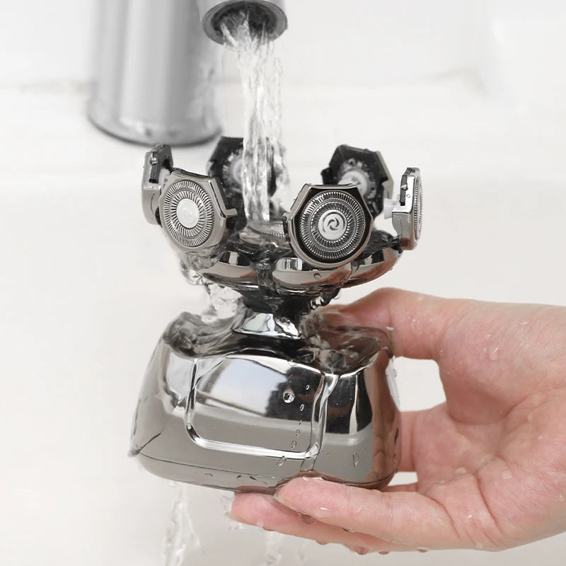 A hand holds a silver electric shaver while water flows over it.