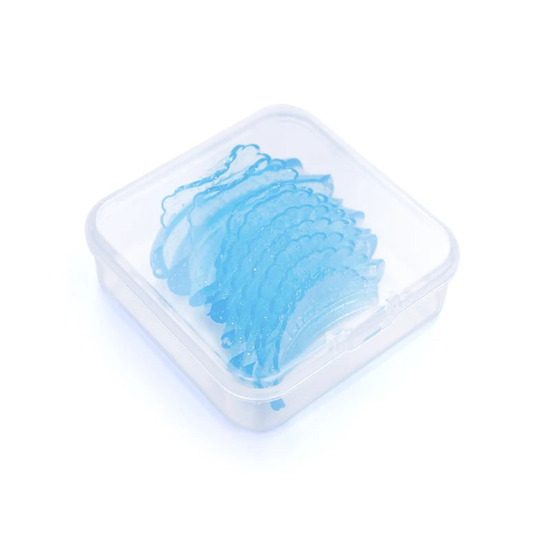Un récipient en silicone transparent contient des tampons de recourbe-cils en silicone bleu.