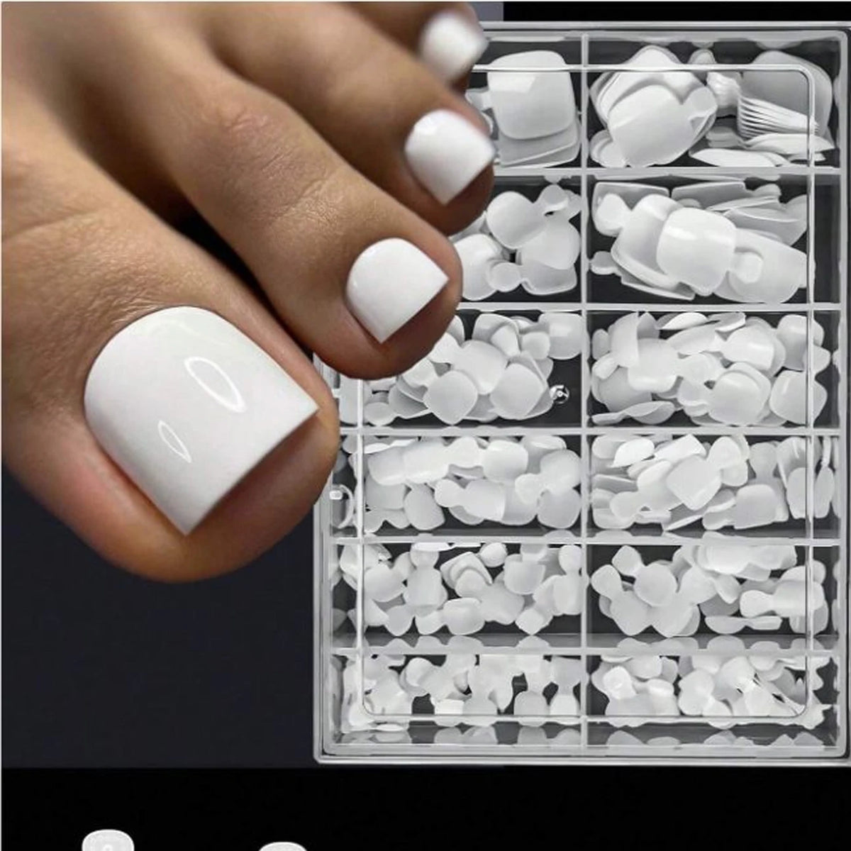 A hand displays a set of white reusable press-on acrylic false nails organized in a clear plastic case.