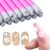 Un set de rotuladores para uñas rosa y blanco con diseños florales y de mariposas, junto a una mano.