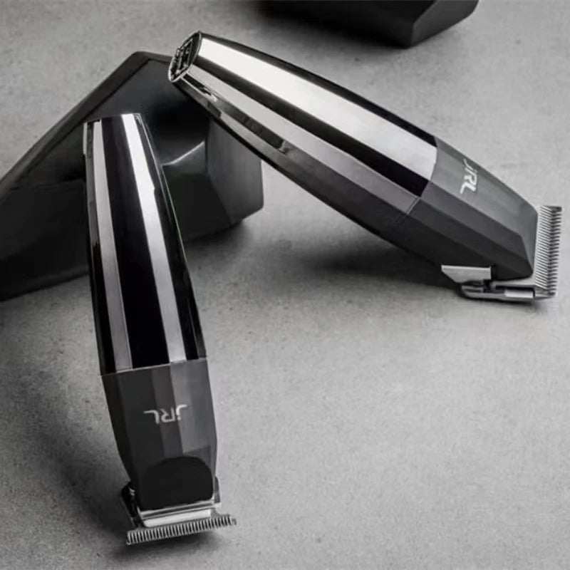 A silver and black professional rechargeable hair clipper is shown angled on a gray surface.