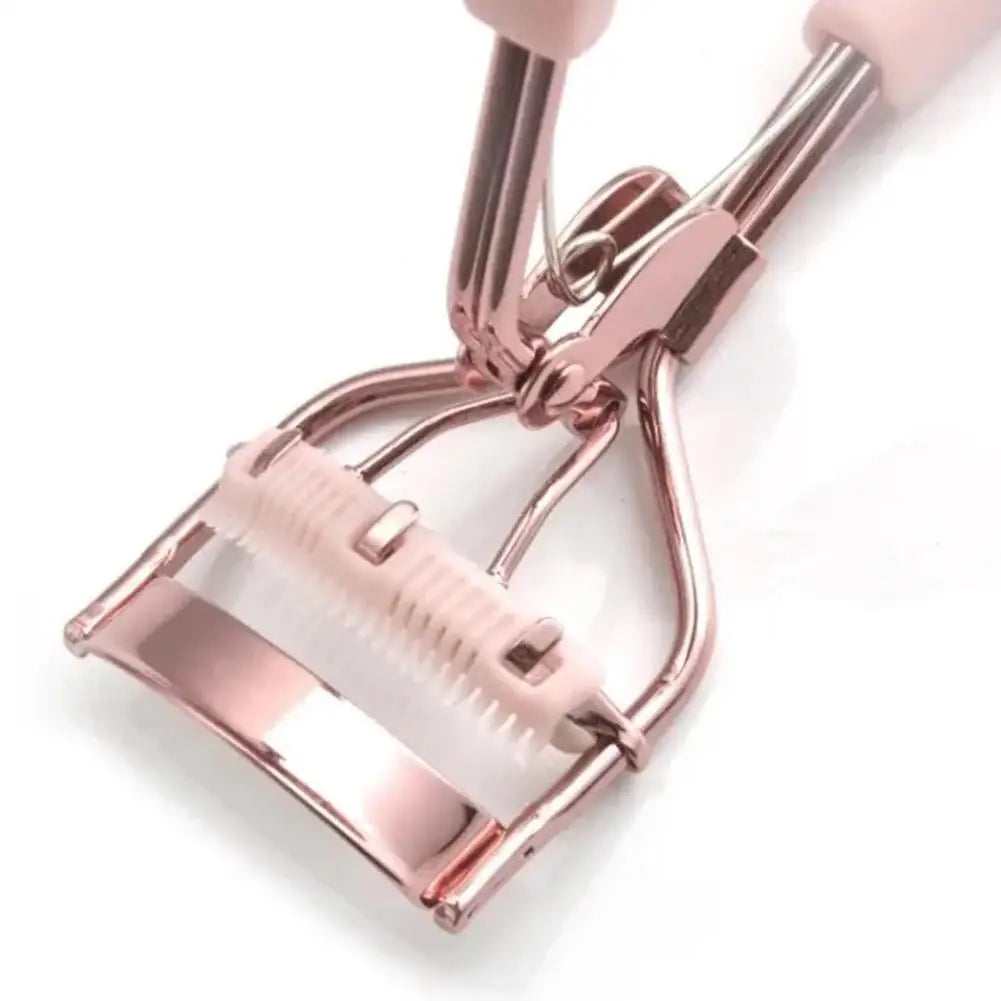 Gros plan d'un recourbe-cils rose professionnel avec une brosse, montrant les composants métalliques et en plastique.