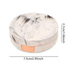 Round contact lens storage box with a marbled white and gray pattern and an orange rim