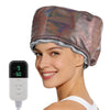 A woman is wearing a shiny, metallic pink hair steamer cap while holding an electric hair steamer device.