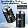 A black portable mini electric shaver with an LED display and charging port shown on a white surface.