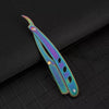 A manual straight edge shaver kit with iridescent purple and blue blades resting on a dark surface.