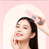 Una mujer usa un dispositivo eléctrico rosa en su rostro para promover piel suave y luminosa.