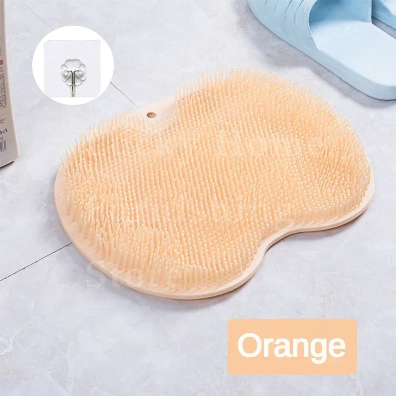 A round, light orange silicone foot scrubber with dense bristles is shown on a white surface.