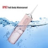 A pink portable oral irrigator device is shown submerged in water, demonstrating its IPX7 waterproof feature.