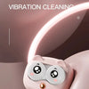 A pink, cat-like creature holds a contact lens cleaning device with a vibration feature.