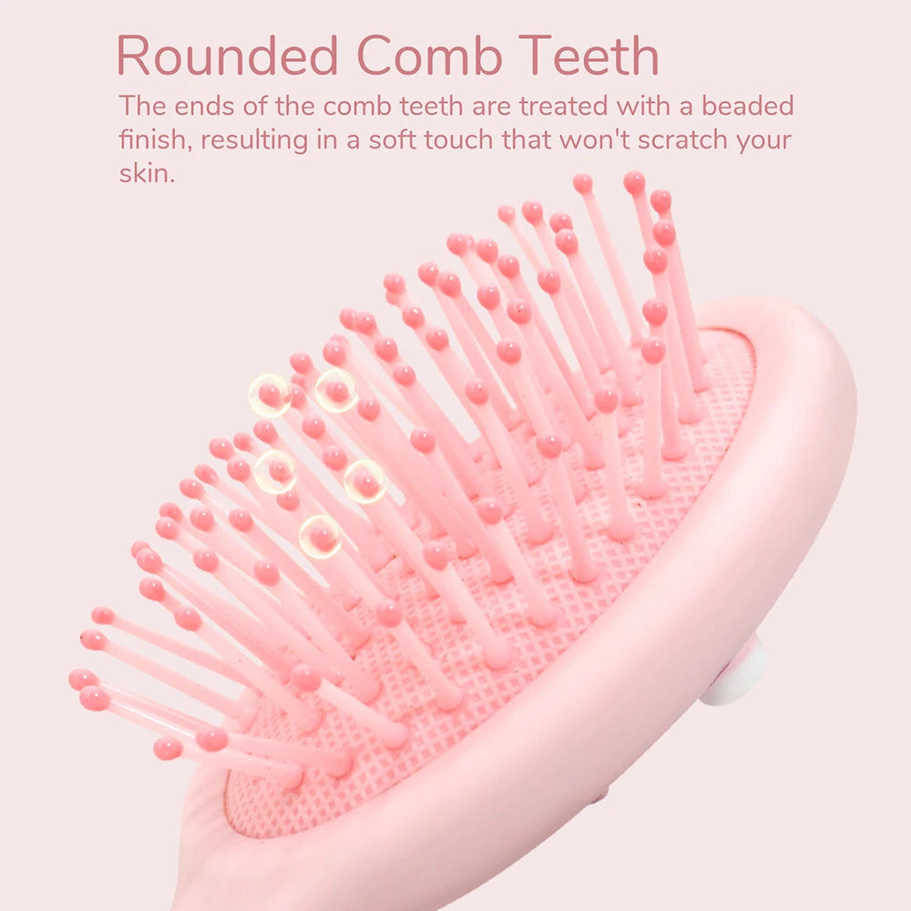 A pink cartoon mini air cushion massage comb with rounded teeth is shown in a close-up view.