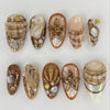 A collection of 24 press-on almond nails featuring various 3D floral and butterfly designs in natural and earthy tones.