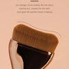 A close-up of a curved foundation brush with golden bristles and a metallic handle.