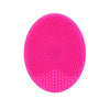 A bright pink silicone facial cleansing brush with numerous small, round bristles.
