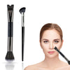 Un set de brochas de maquillaje en forma de U, incluyendo una brocha cónica grande y un pincel abanico pequeño, junto a una m