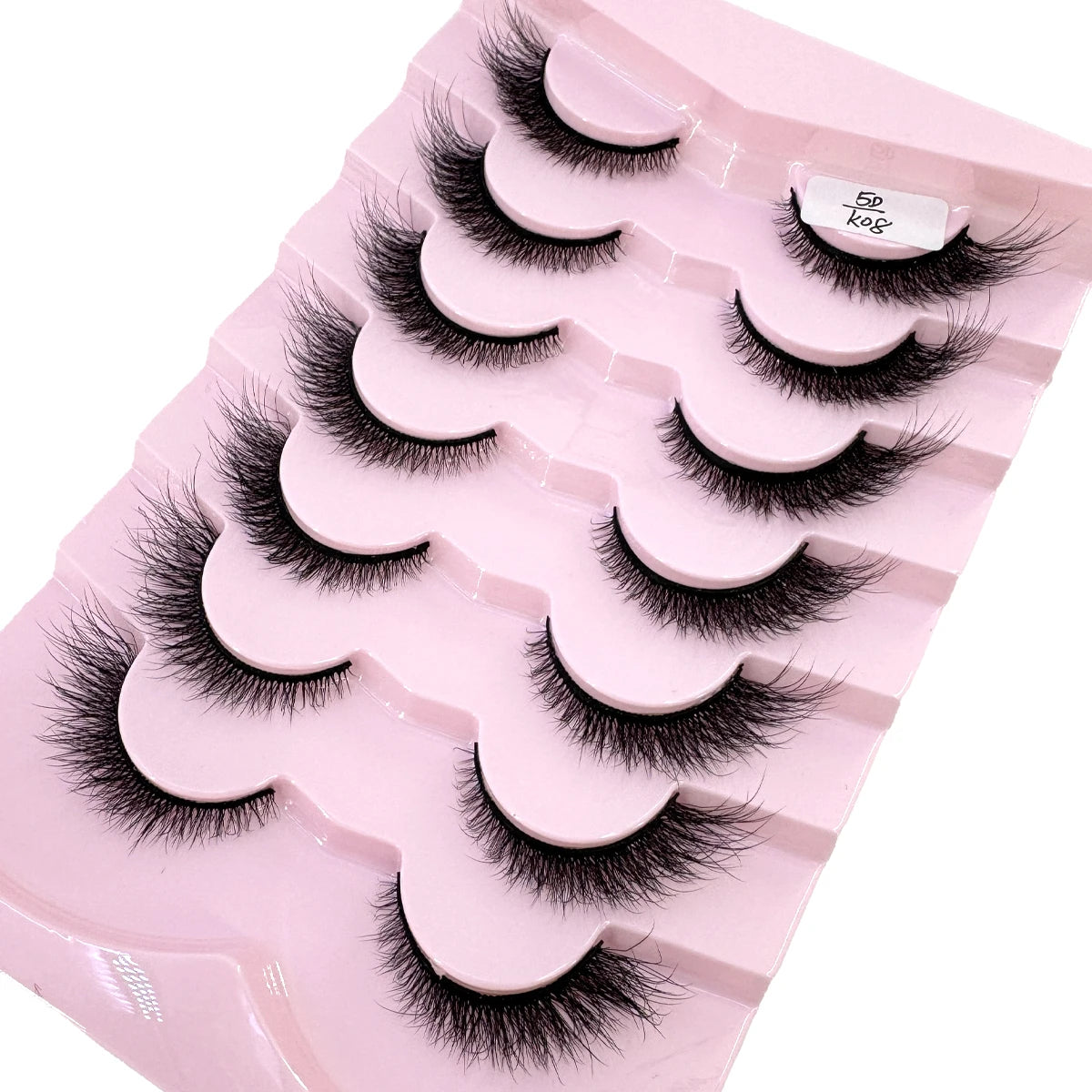 Un plateau en plastique rose contenant un ensemble de faux cils de renard noirs.