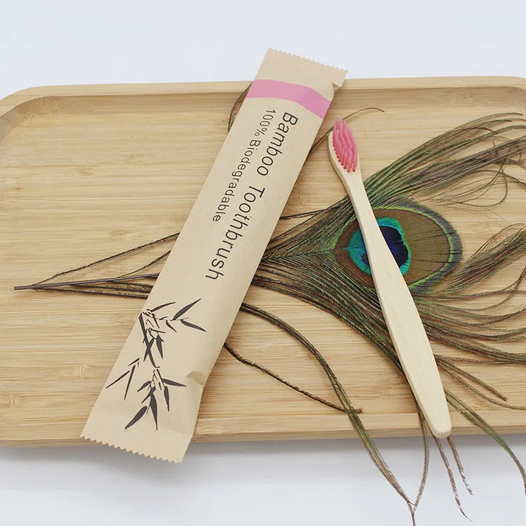A bamboo toothbrush is shown next to a wooden cutting board and dried plant material.
