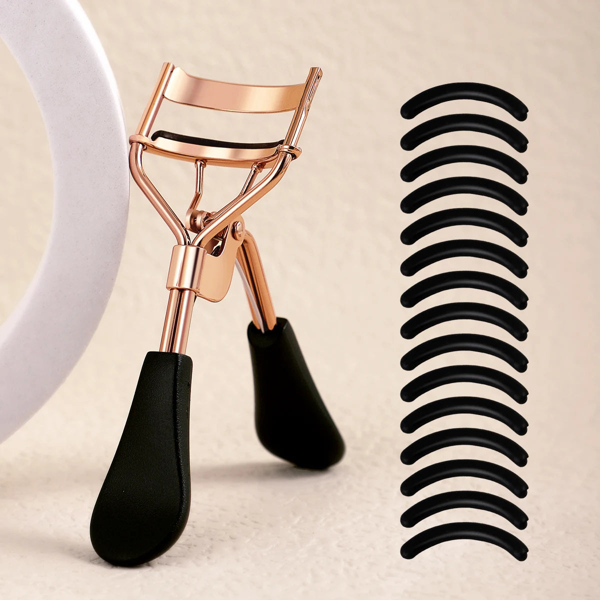 A professional stainless steel eyelash curler set showing the curler tool and a coil of black curler rods.