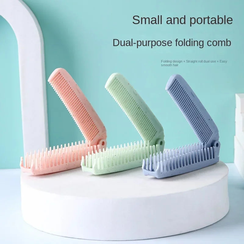 A set of three dual-purpose folding combs in pink, green, and blue are displayed on a white stand.