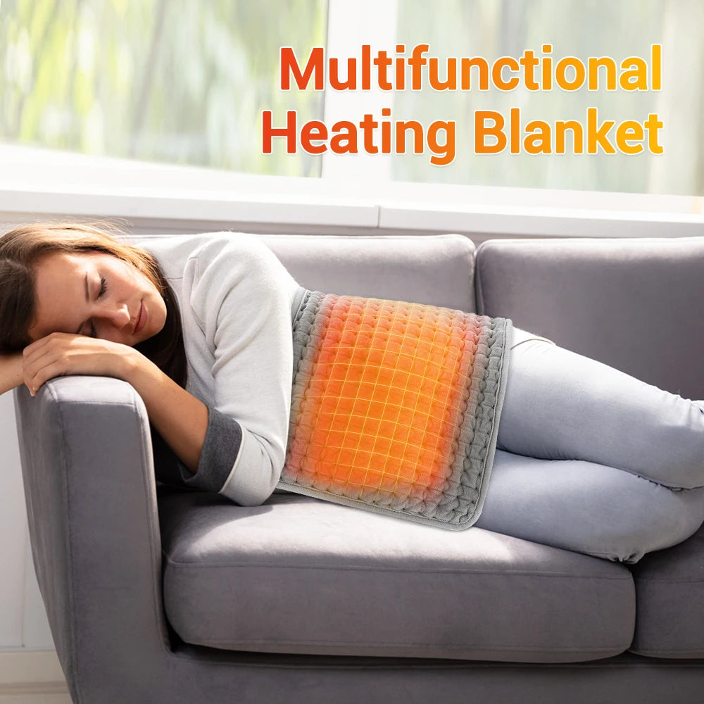 A woman is relaxing on a couch with an orange heating blanket placed across her lap.