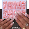 A set of 240 press-on nails in various shades of pink and other colors displayed on hands.